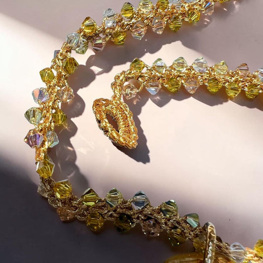 Close-up of handmade crochet necklace with Swarovski crystals in soft Mediterranean colors