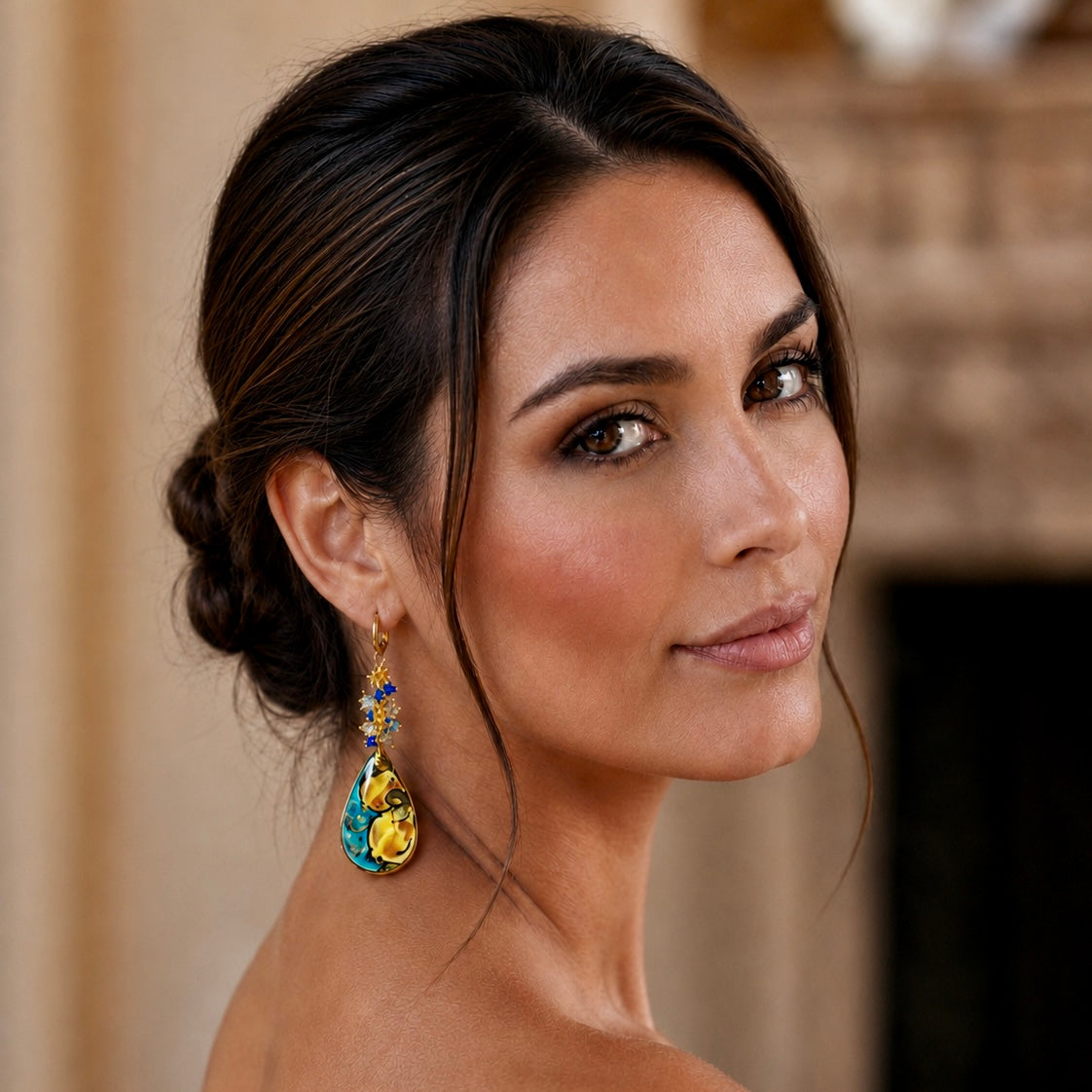 Woman wearing handmade Sicilian drop earring with hand-painted Caltagirone ceramic lemon motif and blue Swarovski crystals