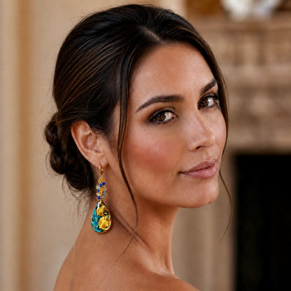 Woman wearing handmade Sicilian drop earring with hand-painted Caltagirone ceramic lemon motif and blue Swarovski crystals