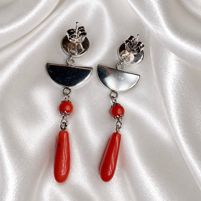 Back view of Sardinian red coral and rhodium-plated silver earrings, showing butterfly backs and semicircle links on white satin.