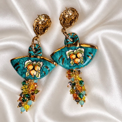 Rear view of turquoise Caltagirone ceramic coffa earrings, showing stud posts, clear disc backs, and multicolored Swarovski crystal clusters.