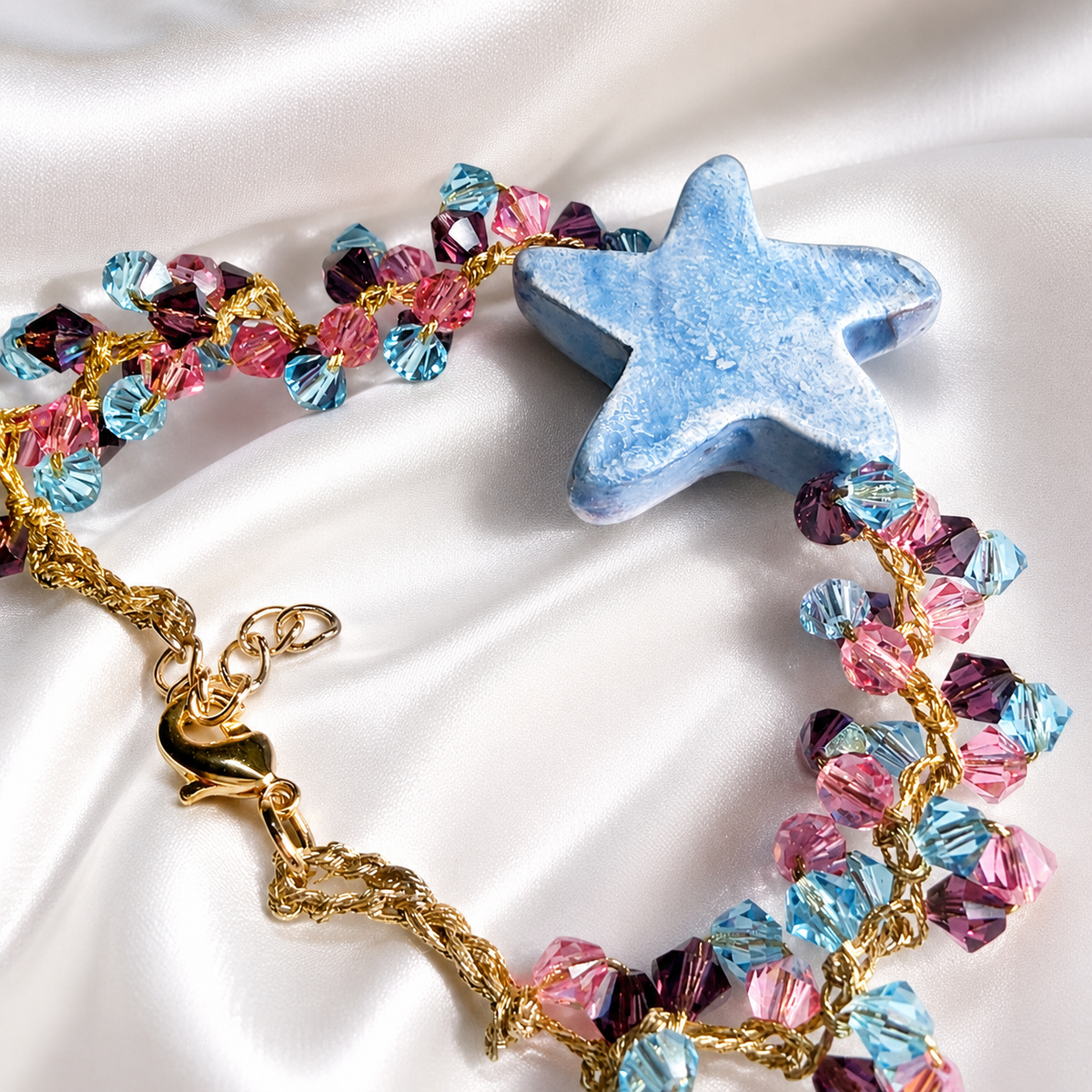 Back view of handmade Sicilian ceramic starfish bracelet with blue ceramic starfish and pink and blue Swarovski crystals