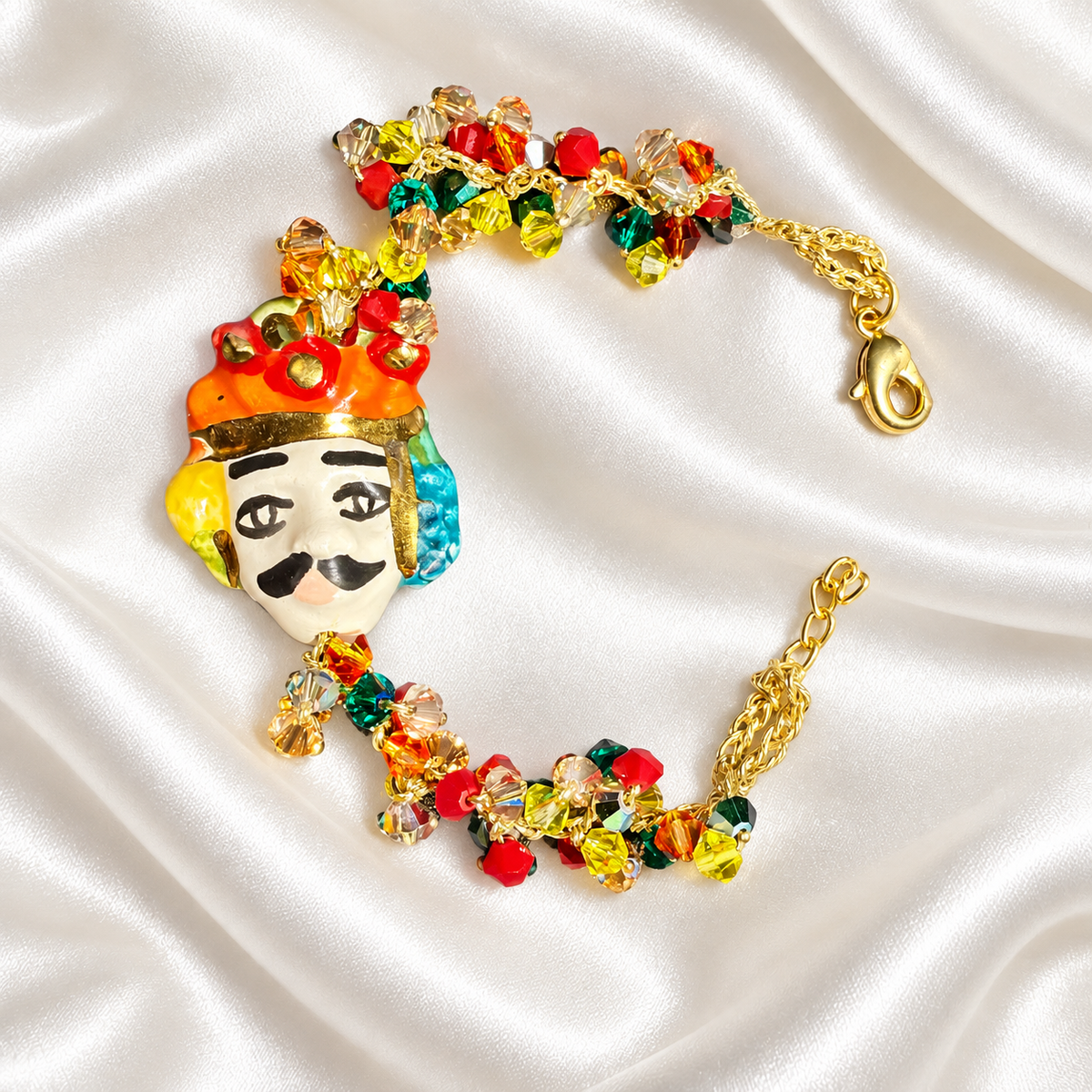Handmade Sicilian bracelet with hand-painted ceramic Moor’s Head, 15% gold lustre, multicolored Swarovski crystals and gold-plated brass chain.
