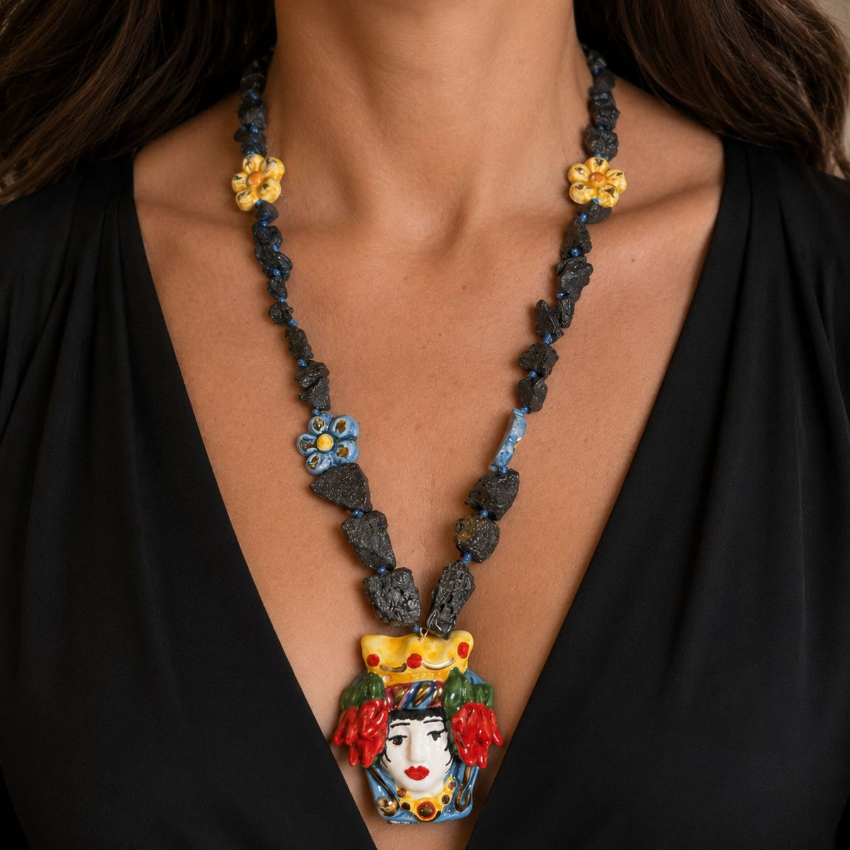 Woman wearing handmade Sicilian Testa di Moro necklace with Etna lava stone and hand-painted Caltagirone ceramic details