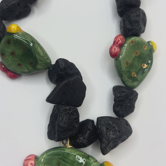 Video close-up of handmade Sicilian prickly pear pendant in hand-painted Caltagirone ceramic with Mount Etna lava stone necklace