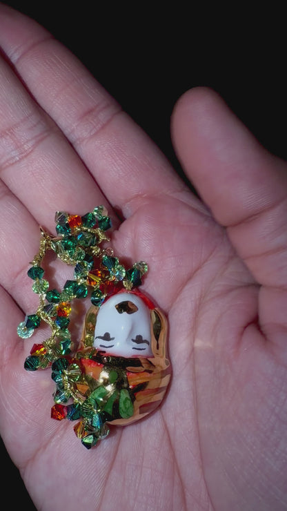 Video showing Moor’s Muse handmade Sicilian Testa di Moro bracelet with green and orange Swarovski crystals held in hand