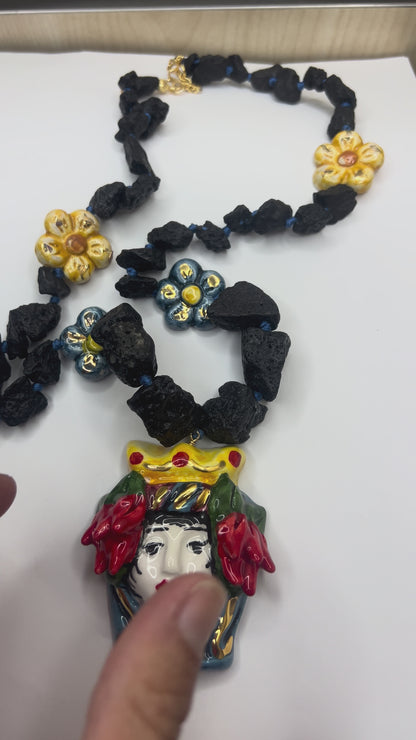 Blue hand-painted Caltagirone ceramic flower surrounded by natural Etna lava stones on Sicilian handmade jewelry